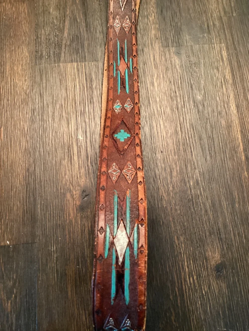 Vintage Siskiyou Buckle Co. enameled belt buckle paired with tooled leather belt